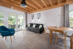 a living room with a couch and a table and chairs at Zachodni Wiatr - Dom Fok in Białogóra