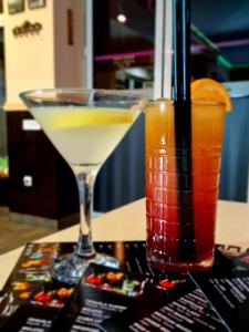 un martini y una bebida sentado en una mesa en B&B Alex18 en Niš