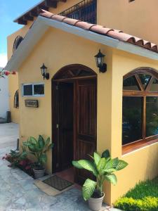 een huis met een bruine deur en wat planten bij Zandoyo Bed & Breakfast in Puerto Escondido