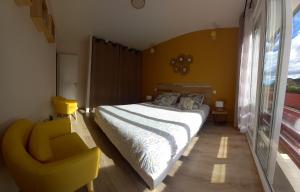 ein Schlafzimmer mit einem Bett und einem gelben Stuhl in der Unterkunft Gite la Pale de Peggy et Sylvain in Saint-Pé-de-Bigorre