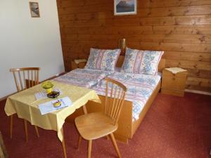a bedroom with a bed and a table and chairs at Pension Edelweiss in Sankt Martin am Tennengebirge