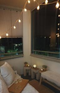 ein Wohnzimmer mit einem Sofa und einem Fenster mit Beleuchtung in der Unterkunft Modern apartment with sauna and free parking in Kuopio