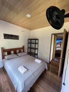 a bedroom with a large bed and a fan at Casa Palmera in Puntarenas