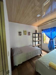 a bedroom with two beds and a window at Casa Palmera in Puntarenas