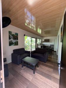 a living room with two couches and a table at Casa Palmera in Puntarenas