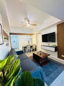 a living room with a blue couch and a table at 1 Bedroom - The Bali Getaway @ Azure North in San Fernando