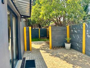 a fence with yellow posts next to a building at Lemon Ivy Guesthouse in Polokwane