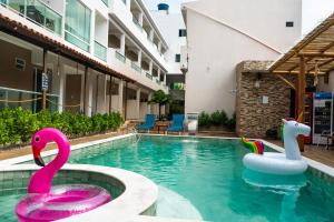 two swans in a swimming pool in a hotel at Pousada Concha Dourada in Maragogi
