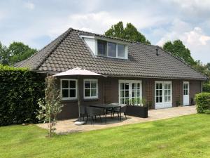a house with a table and chairs in a yard at Onder het dak van Brabant in Mierlo
