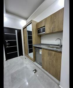 uma cozinha vazia com armários de madeira e um lavatório em رويال جروب للشقق الفندقية em Irbid