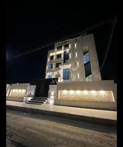 un edificio con luces encendidas por la noche en رويال جروب للشقق الفندقية, en Irbid