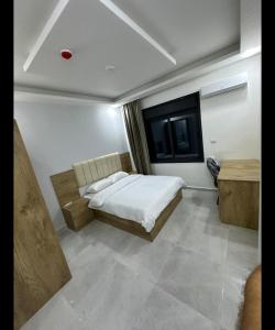 um quarto com uma cama e uma janela em رويال جروب للشقق الفندقية em Irbid