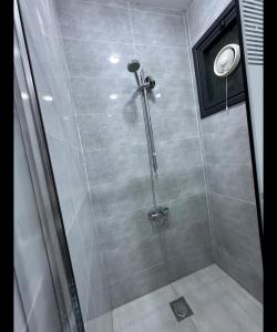 um chuveiro com uma porta de vidro na casa de banho em رويال جروب للشقق الفندقية em Irbid
