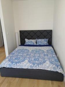 - un lit avec une couette et des oreillers bleus et blancs dans l'établissement B23 Apartments, à Vilnius