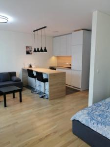 Il comprend une cuisine et un salon avec une table et des chaises. dans l'établissement B23 Apartments, à Vilnius