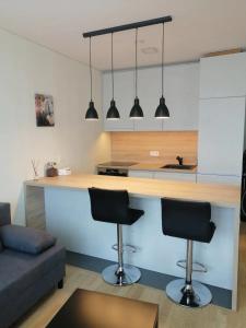 - une cuisine avec deux tabourets de bar dans le salon dans l'établissement B23 Apartments, à Vilnius