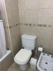 a bathroom with a white toilet and a sink at Confort urbano. Alójate en el corazón de Rosario in Rosario +10 photos