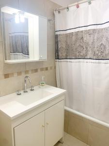 a white bathroom with a sink and a shower at Confort urbano. Alójate en el corazón de Rosario in Rosario
