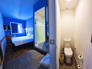 Habitación azul con baño con cama y aseo en ibis budget Iquique en Iquique