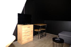 Zimmer mit einem Schreibtisch, einem TV, einem Tisch und einem Stuhl in der Unterkunft Mini apartmán v Jizerských horách in Jablonec nad Nisou