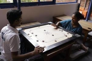 un hombre y una mujer jugando un juego de mesa en Live Free Hostel Varanasi en Varanasi