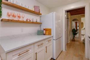 kuchnia z białymi szafkami i białą lodówką w obiekcie Hope Home w mieście Clermont