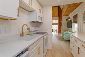 una cocina con armarios blancos y fregadero en Hope Home, en Clermont