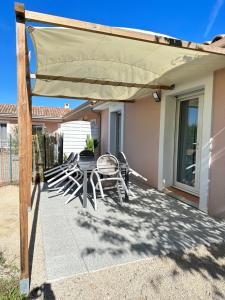 d'une terrasse avec une table et des chaises sous un auvent. dans l'établissement Maison Joyce, à Montauban