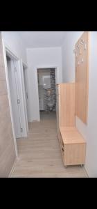 einen Flur eines Zimmers mit einer Küche und einem Holzschrank in der Unterkunft DM apartman in Ruma