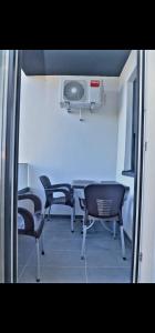 Zimmer mit Stühlen und einem Tisch mit Ventilator in der Unterkunft DM apartman in Ruma