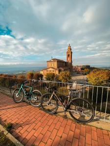 three bikes parked next to a fence with a clock tower at Langhe e Roero - Casa da Angela in Sommariva Perno