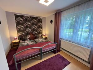 een slaapkamer met een bed en een groot raam bij Ferienwohnung Herzstück in Willingen