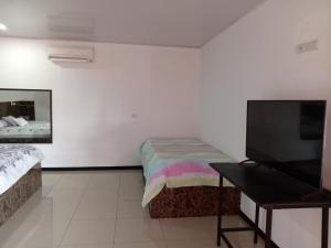 Schlafzimmer mit einem Bett und einem Flachbild-TV in der Unterkunft COLIBRÍ TINY HOUSES in Fortuna