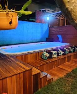 una gran bañera de hidromasaje con almohadas en una terraza de madera en Hostel Trem Di Durmi en Belo Horizonte