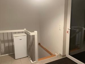 a room with a small refrigerator and a staircase at Messe Apartment in Hannover