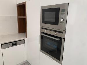 een keuken met een magnetron en een oven bij Prince Palace Hadera Beach in H̱adera