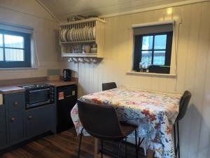 cocina con mesa y mantel con flores en Rathgillen Cabin, en Nobber