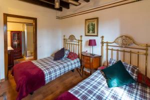 a bedroom with two beds and a table with a lamp at LA KASONA in Córdoba