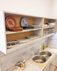 a kitchen with a sink and plates and dishes at Maria in Sidi Bou Saïd