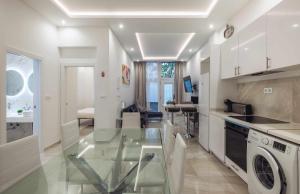 uma cozinha com uma mesa de vidro e uma sala de estar em Lujo exclusividad espacioso Madrid centro em Madri