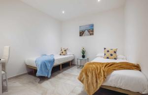 - une chambre avec 2 lits et une couverture dans l'établissement Lujo exclusividad espacioso Madrid centro, à Madrid
