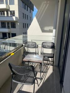 three chairs and a table on a balcony with a building at Golden Apartments Skopje in Skopje