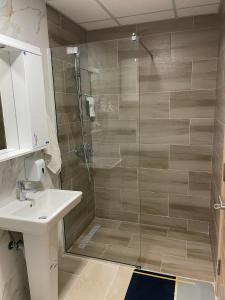 een badkamer met een douche en een wastafel bij Golden Apartments Skopje in Skopje