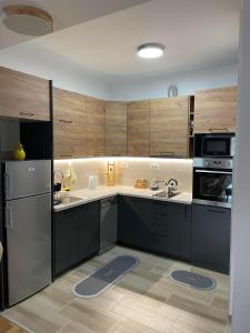 een keuken met zwarte kasten en een koelkast bij Golden Apartments Skopje in Skopje