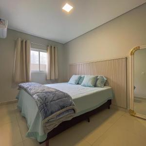 un dormitorio con una cama y una ventana en Apto Adilson, en Foz do Iguaçu