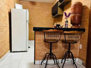 uma cozinha com um balcão com bancos e um frigorífico em GV Apartamentos- 2qt-ar cond- area central com vista espetacular em Governador Valadares