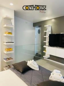 a room with a bed and a tv and shelves at Cozy House in Enna