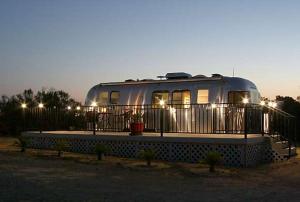 Ein Wohnwagen parkt hinter einem Zaun mit Licht in der Unterkunft Sunrise Suite in Paso Robles