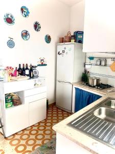 una cucina con frigorifero e lavandino di Villino dei Dori, Marinella di Selinunte a Marinella di Selinunte