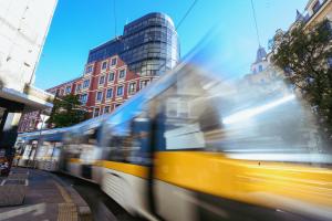 a bus driving down a city street with buildings at LOCATION in Sofia